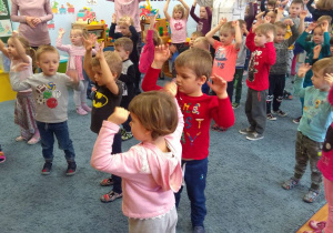 Dzieci tańczą z podniesionymi rękami